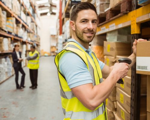 Close,Up,Of,Warehouse,Worker,Scanning,Box,While,Smiling,At